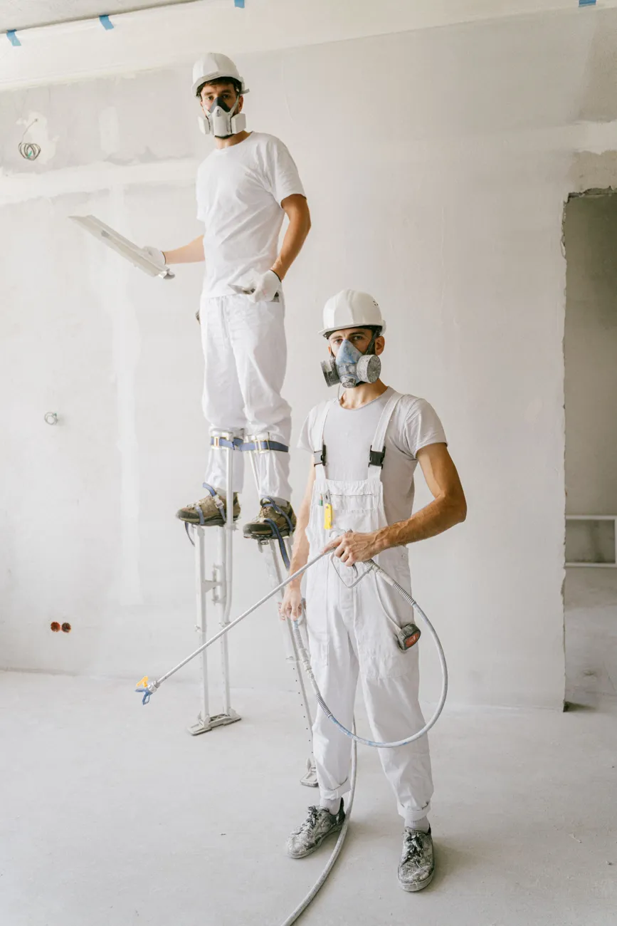 Two painters in protective suits on a finishing job
